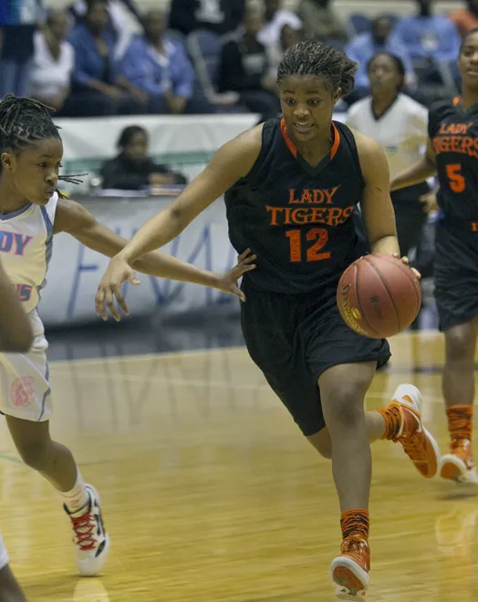 Dunbar High School's Kiara Desamours (12) drives towards the basket against Ribault High School during their FHSAA Girls Basketball 4A Championship Final game at the Lakeland Center. Dunbar won the game 50-41. February 23, 2012.