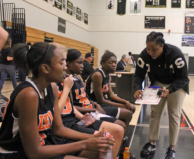 Lely coach Kirsti Jones diagrams a play during a timeout in the Trojans loss to Immokalee in the open round of the Class 4A-District 14 playoffs on Jan. 29, 2013.