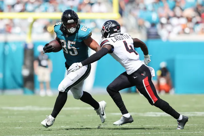 Sep 21, 2025; Jacksonville, Florida, USA; Jacksonville Jaguars tight end Brenton Strange (85) runs the ball against Houston Texans cornerback Kamari Lassiter (4) during the third quarter at EverBank Stadium. Mandatory Credit: Morgan Tencza-Imagn Images
