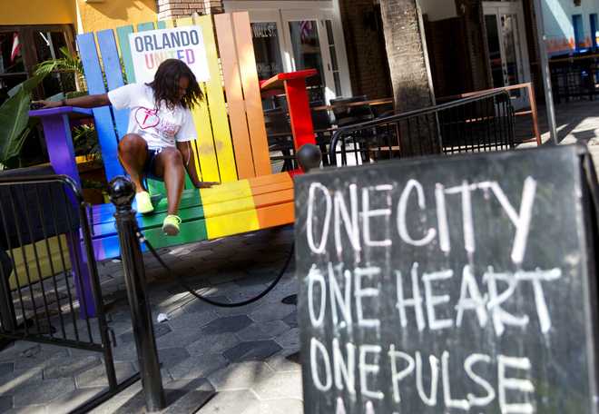 Elizabeth Newsome Elizabeth Newsome, of Orlando, jumps off a large chair outside a bar painted in the colors of a rainbow as a tribute to the victims of the Pulse nightclub mass shooting Saturday, June 18, 2016, in Orlando, Fla. (AP Photo/David Goldman)