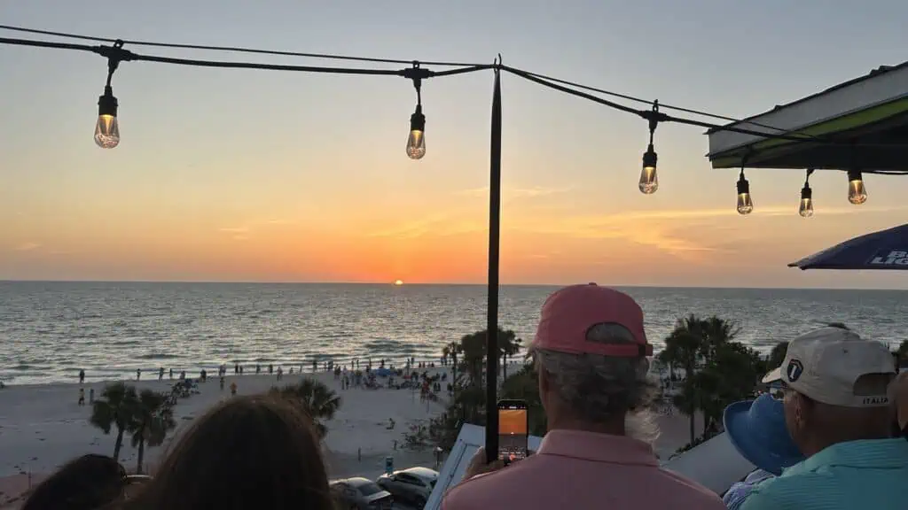 a group of people viewing the sunset from a rooftop bar
