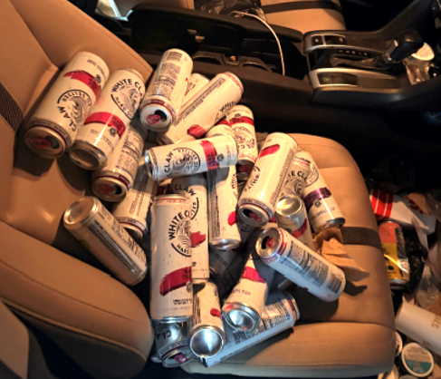 Empty White Claw cans littering a car seat.