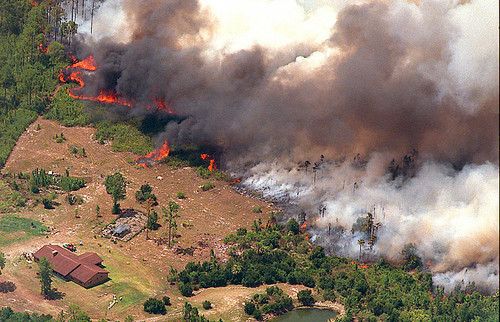 A lone house sits in the path of a raging brushfire in Brevard County on July 2, 1998, just west of Mimms, Fla. Wildfires devoured dozens of homes in Central Florida and forced the evacuation of over 30,000 residents. (Orlando Sentinel file)