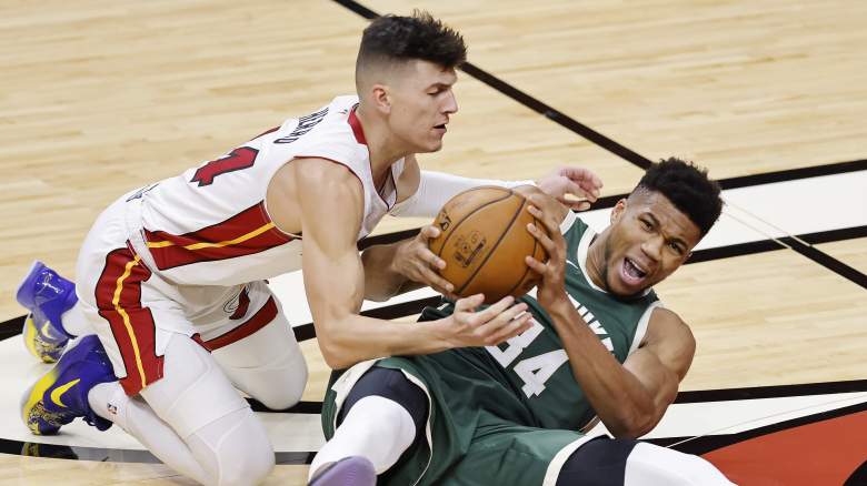 Tyler Herro and Giannis Antetokounmpo scramble for possession during an NBA game.