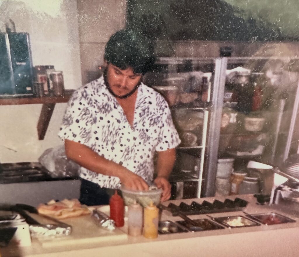 A person making hot dogs