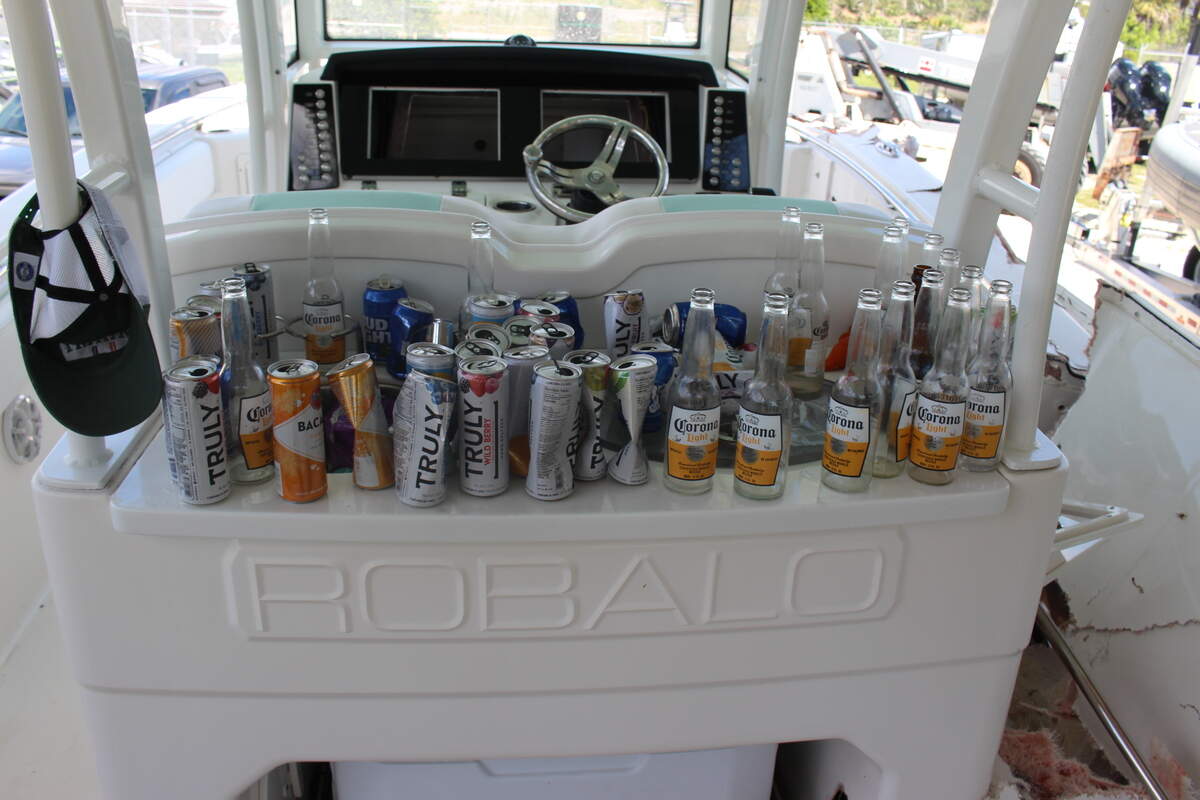 Empty and partially empty beer and other alcoholic beverage bottles and cans are lined up behind the cockpit of George Pino’s 29-foot Robalo boat on Sept. 5, 2022, the day after the crash.