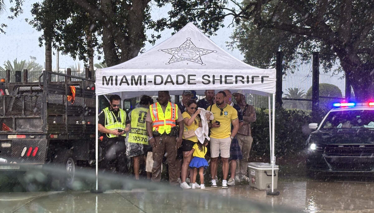 Tartan Army and Brazil fans huddled with Miami-Dade County sherriff’s officers under one of the few covered areas outside Hard Rock Stadium while waiting for the gates to open.