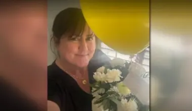 Former Trout Creek Academy Principal Katherine O'Connell smiles with flowers she received from rapper Fetty Wap