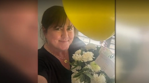 Former Trout Creek Academy Principal Katherine O'Connell smiles with flowers she received from rapper Fetty Wap