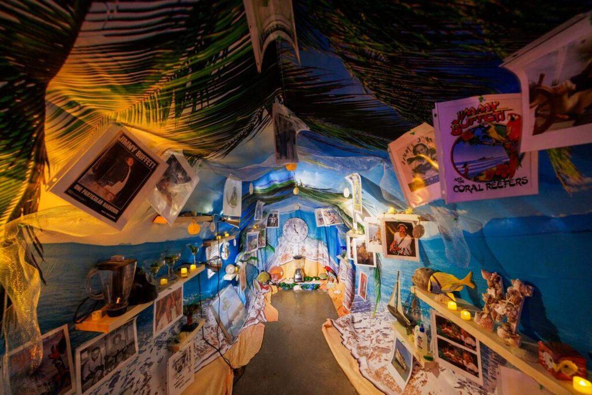 Visitors are invited to walk inside the margarita — a dense, found‑object sculptural environment of memorabilia-style elements assembled from collected materials.