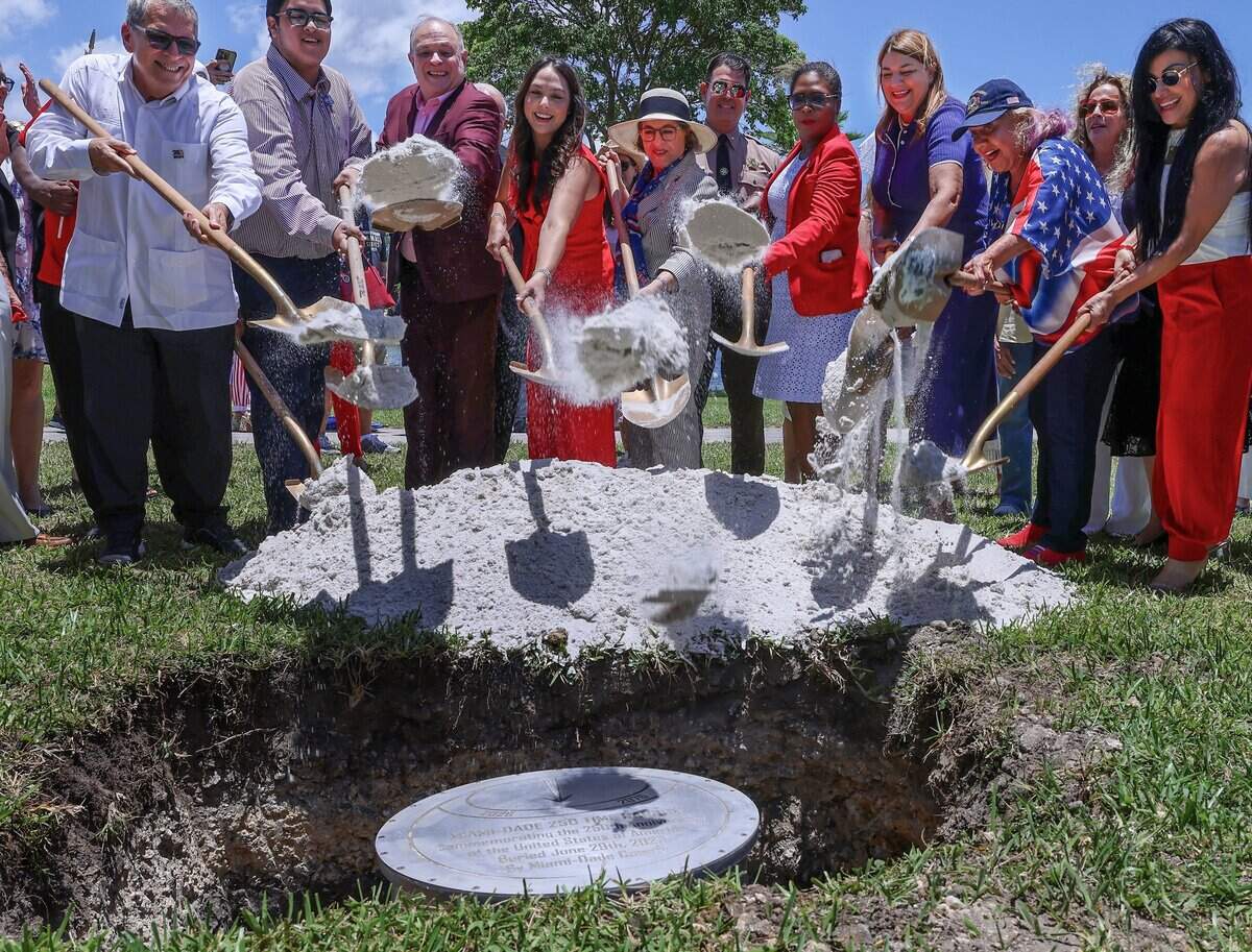 Miami-Dade Commissioner Natalie Milian Orbis, center left, and Mayor Daniella Levine Cava, center right, join other officials and stakeholders in placing sand over the 2026 time capsule during a ceremony marking America's 250th anniversary at Tropical Park on Monday, June 29, 2026, in Miami-Dade County. The event included the installation of the time capsule and the unveiling of the America 250 Patriot Marker. The event celebrated the nation's history and aimed to preserve the present for future generations. The Miami-Dade 250 time capsule will remain sealed for 50 years, to be opened at the tricentennial in 2076, preserving the stories, achievements and cultural spirit of the community.