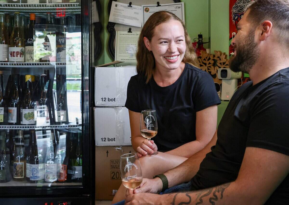 Jasmine Fonseca, left, and husband Arturo Fonseca, right, are regulars who enjoy wine and company at Champagne Shack in Hollywood, Florida, on Wednesday, June 10, 2026. Patrons often gather late at the independently owned wine bar, known for its relaxed atmosphere and community feel. Champagne Shack is a small, independently owned wine bar that draws local residents with its casual atmosphere. The bar regularly features food vendors on weekends, pop-up events with area restaurants, yoga sessions, a wine club, and live music or DJ performances in its courtyard on Fridays and Saturdays.
