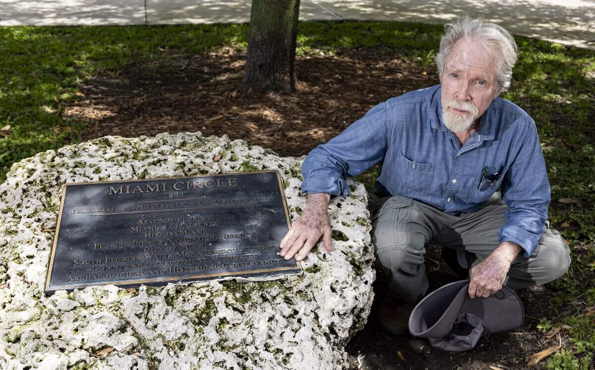 Archaeologist Bob Carr shows off a plaque at Miami Circle National Historic Landmark at the mouth of the Miami River in Brickell. Carr led the excavation of the 2,000-year-old circle, an arrangement of postholes carved in the limestone bedrock that served as the foundation of a ceremonial building erected by the prehistoric Tequesta people, after its 1998 discovery.