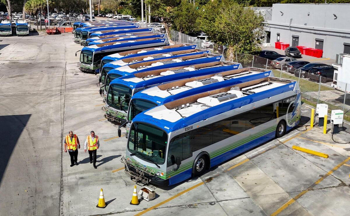Lazaro Dominguez, with the Department of Transportation and Public Works, and Felipe Hermida, Section Chief of Bus Operations, seen left to right, walk past broken electric Proterra buses parked at Miami-Dade County Coral Way Bus Maintenance Facility in Miami on Wednesday, February 19, 2025.