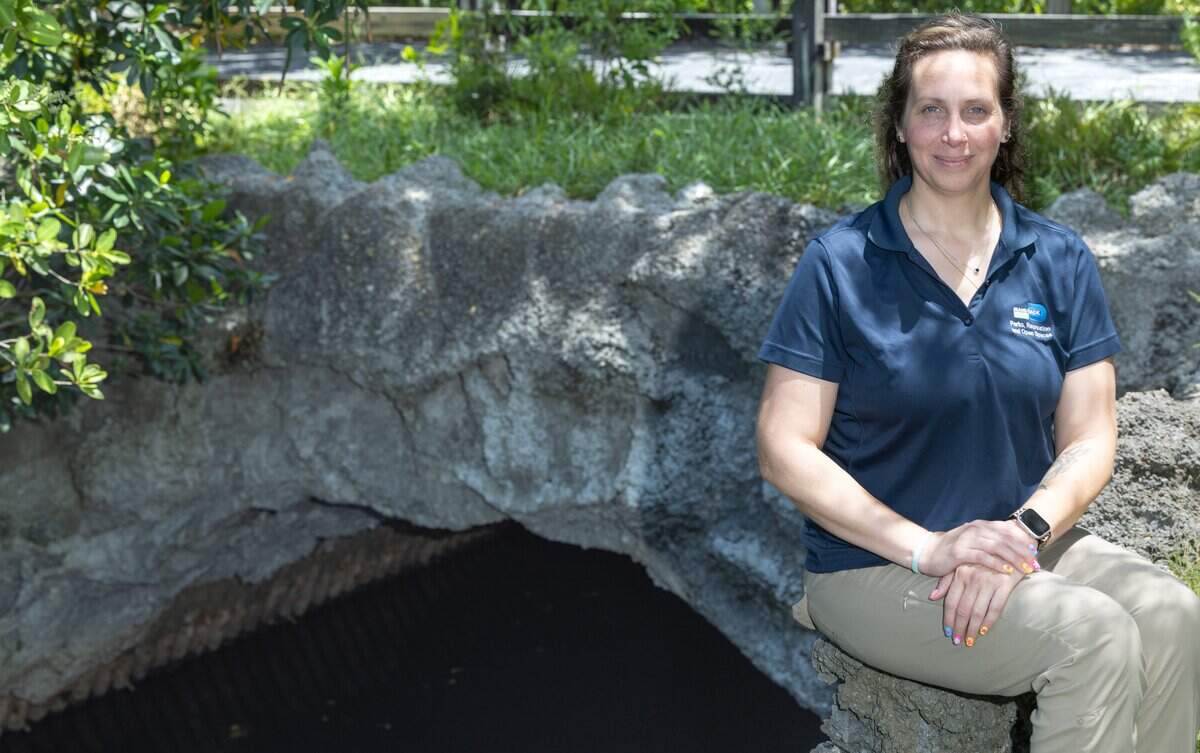 Aimee Scott, interpretive programs supervisor for Miami-Dade Parks, Recreation and Open Spaces, sits in front of the Arch Creek Natural Bridge replica at Arch Creek Park in Miami, Fla., on Tuesday, June 16, 2026.