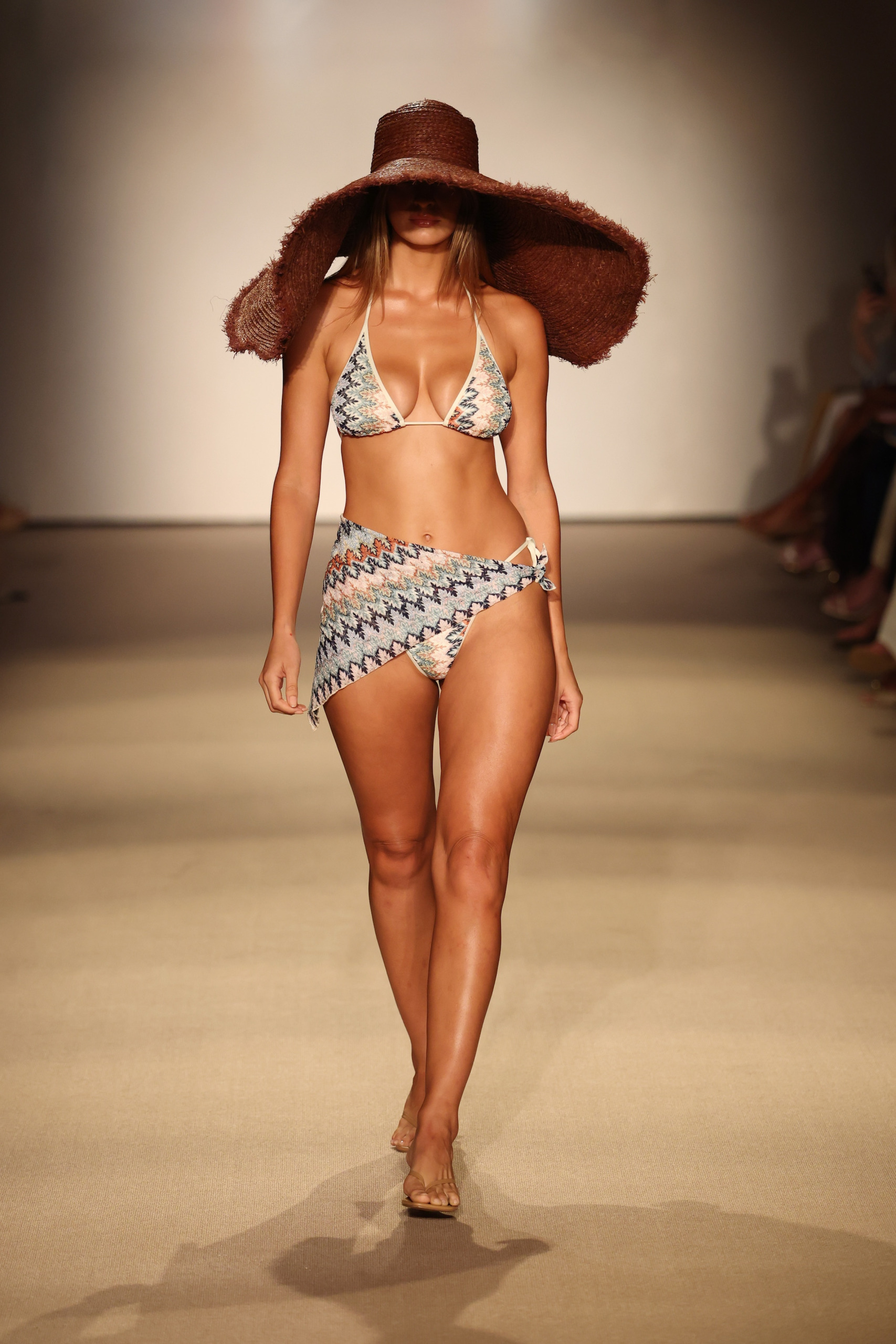 A model in the Monday Swimwear show wears a print design and oversized hat