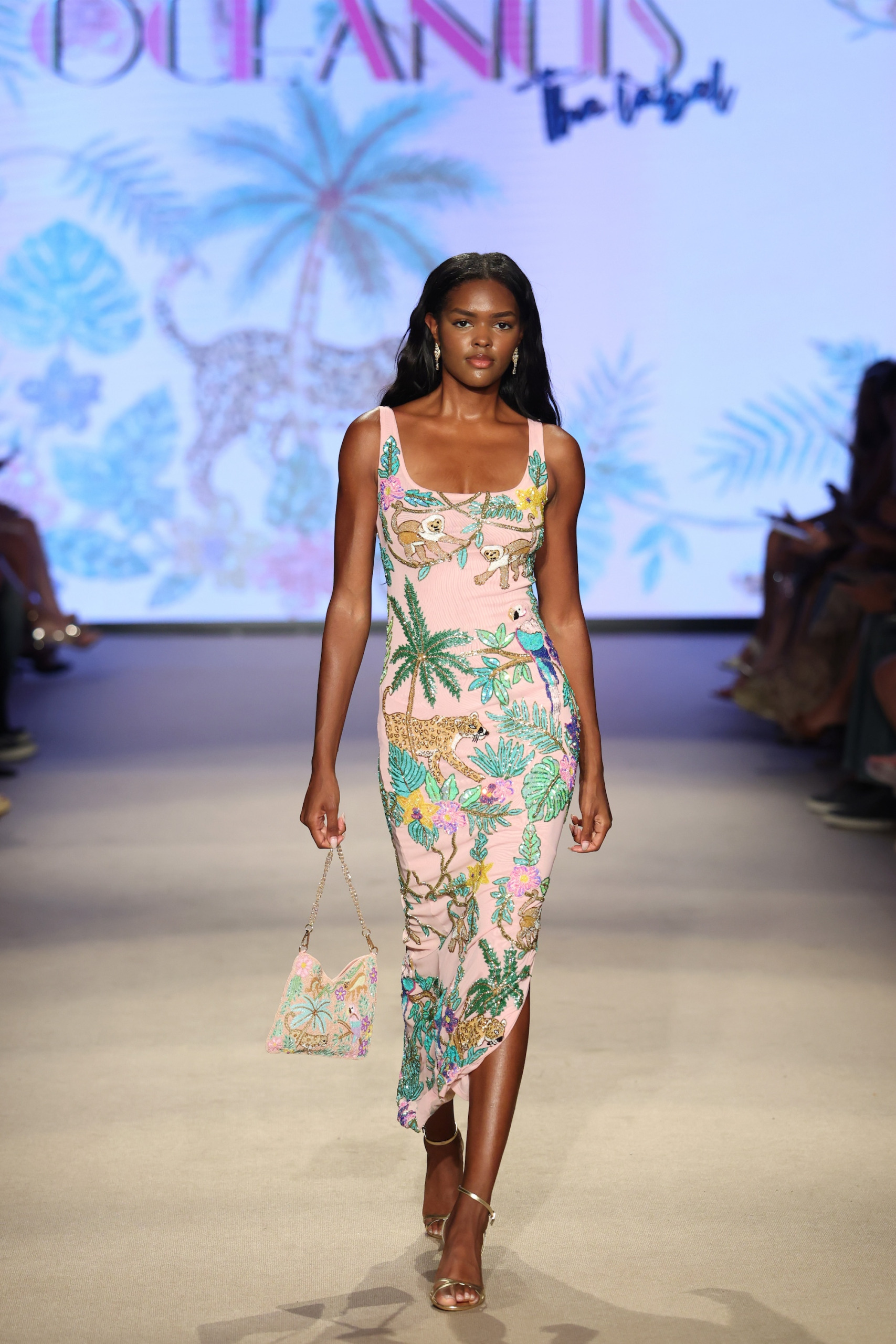 A model walks on the runway wearing a beaded dress from Oceanus's collection