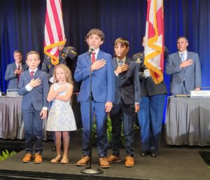 Bar President Michael Fox Orr's children, Michael, Max, Tucker, and Elle, lead the General Assembly in the Pledge of Allegiance at the Bar Convention in Orlando.