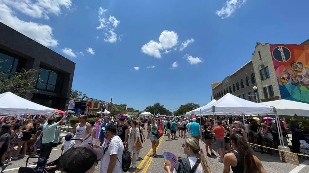a big street festival with vendors on either side of the road