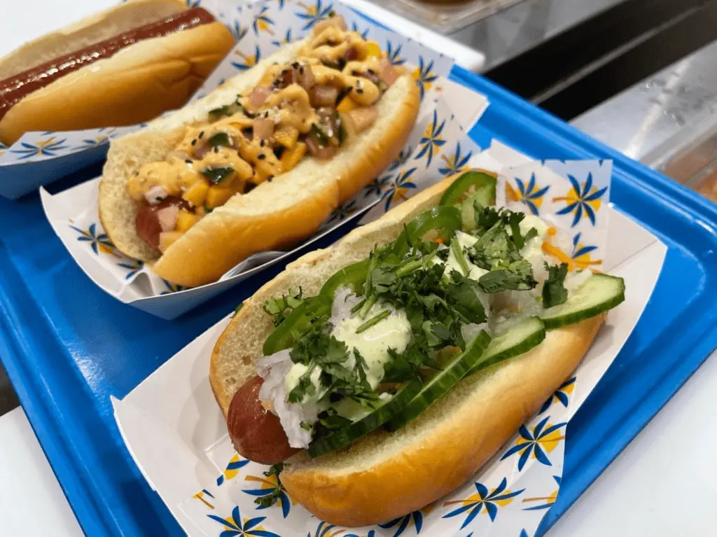 aerial view of three hot dogs covered in toppings