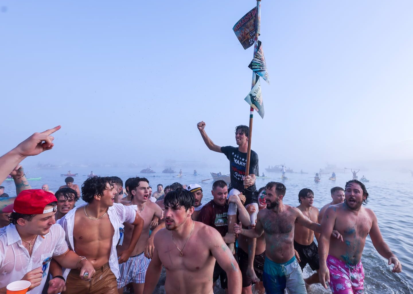 Nick White is carried to the beach after winning the Greasy Pole Contest at Pavilion Beach on June 29.