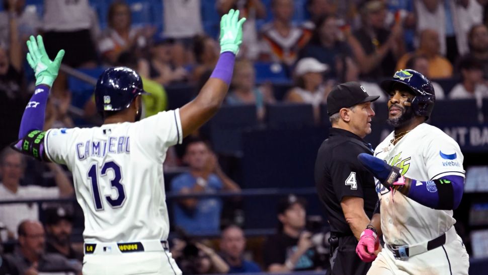 Tampa Bay Rays' Junior Caminero (13) and Yandy Díaz celebrate after Diaz scores on a double by Jonathan Aranda, not pictured, during the seventh inning of a baseball game against the Arizona Diamondbacks Friday, June 26, 2026, in St. Petersburg, Fla. (AP Photo/Jason Behnken)