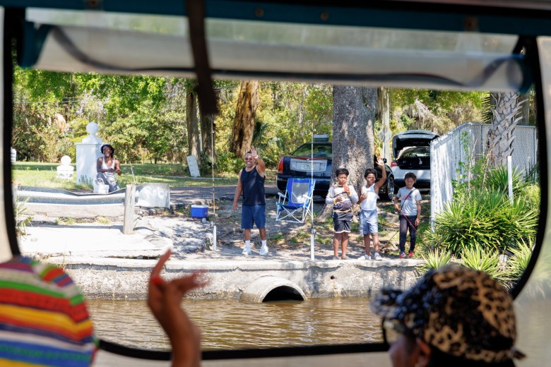 Onlookers wave to family fishing on the banks of the Ribault River, a local waterway identified by the St. Johns River Keeper as in need of remediation due to the presence of fecal coliform bacteria and heavy metals. [Photo by Amanda Rosenblatt for The Florida Trib]