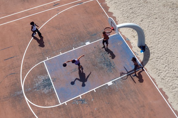 Players join in a pickup game on beachfront basketball courts on Tuesday in Fort Lauderdale. An earlier plan to convert the courts to pickleball was eventually dropped after a loud public outcry. (Mike Stocker/South Florida Sun Sentinel)