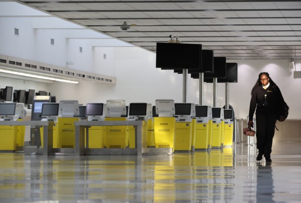 An employee at Fort Lauderdale-Hollywood International Airport walks past a forest of decommissioned Spirit Airlines yellow check-in kiosks in the once-bustling Terminal 4, Wednesday, June 17, 2026. (Joe Cavaretta/South Florida Sun Sentinel)
