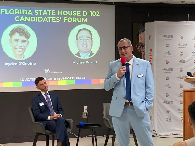 Jayden D'Onofrio, seated, watches Mike Friend speak during a Dolphin Democrats candidate forum in Wilton Manors on May 13, 2026. They are competing in the Democratic primary for House District 102 in Broward County. (Anthony Man, South Florida Sun Sentinel)