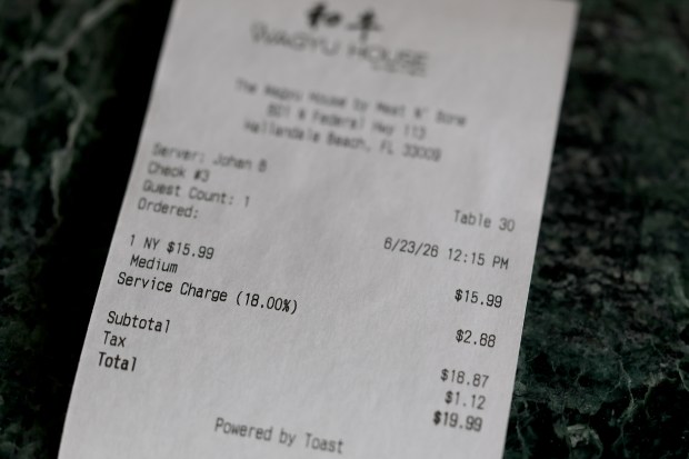 An 18% service charge is printed as a line item on each bill at The Wagyu House in Hallandale Beach. Photographed on Tuesday, June 23, 2026. Starting July 1, Florida's new "Operations Charge" law mandates that all restaurants clearly label their automatic gratuities (credit card fees, delivery fees, split-plate fees) on printed menus, websites, bills of sale, etc., or face steep fines between $100 and $1,000 per violation. (Amy Beth Bennett / South Florida Sun Sentinel)