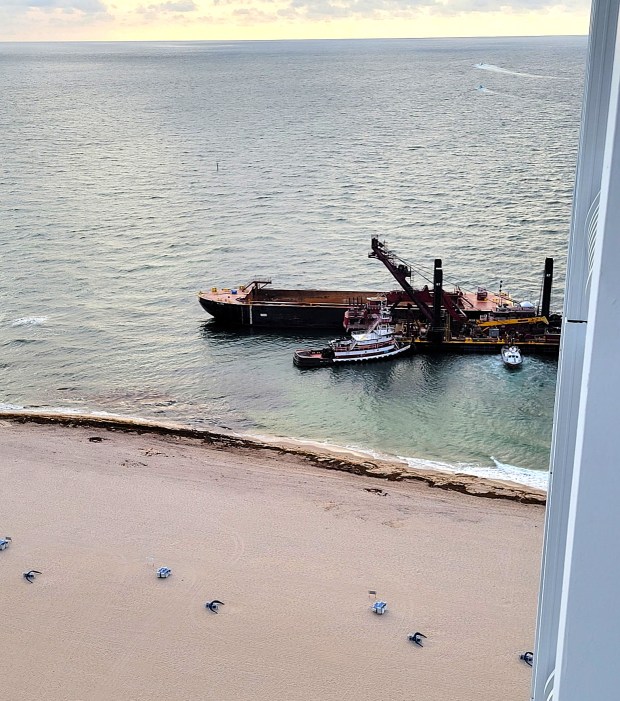 This photos, taken by condo owner Lenny Abrams, shows the Sand Bypass barge and tugboat close to the beach in front of the Points of America condo building near Port Everglades. (Lenny Abrams)