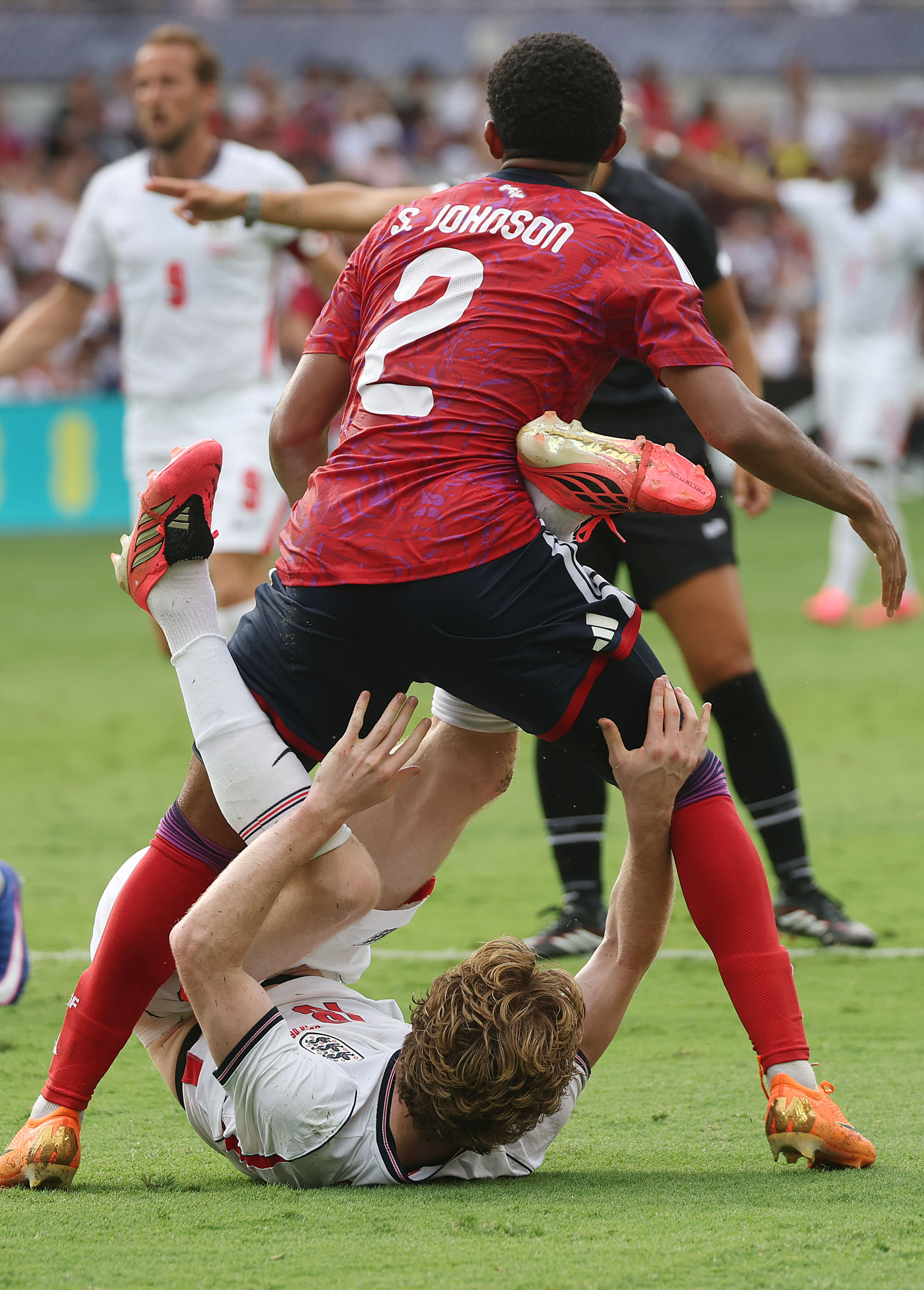 England player Anthony Gordon (bottom) struggles under Costa Rica player...