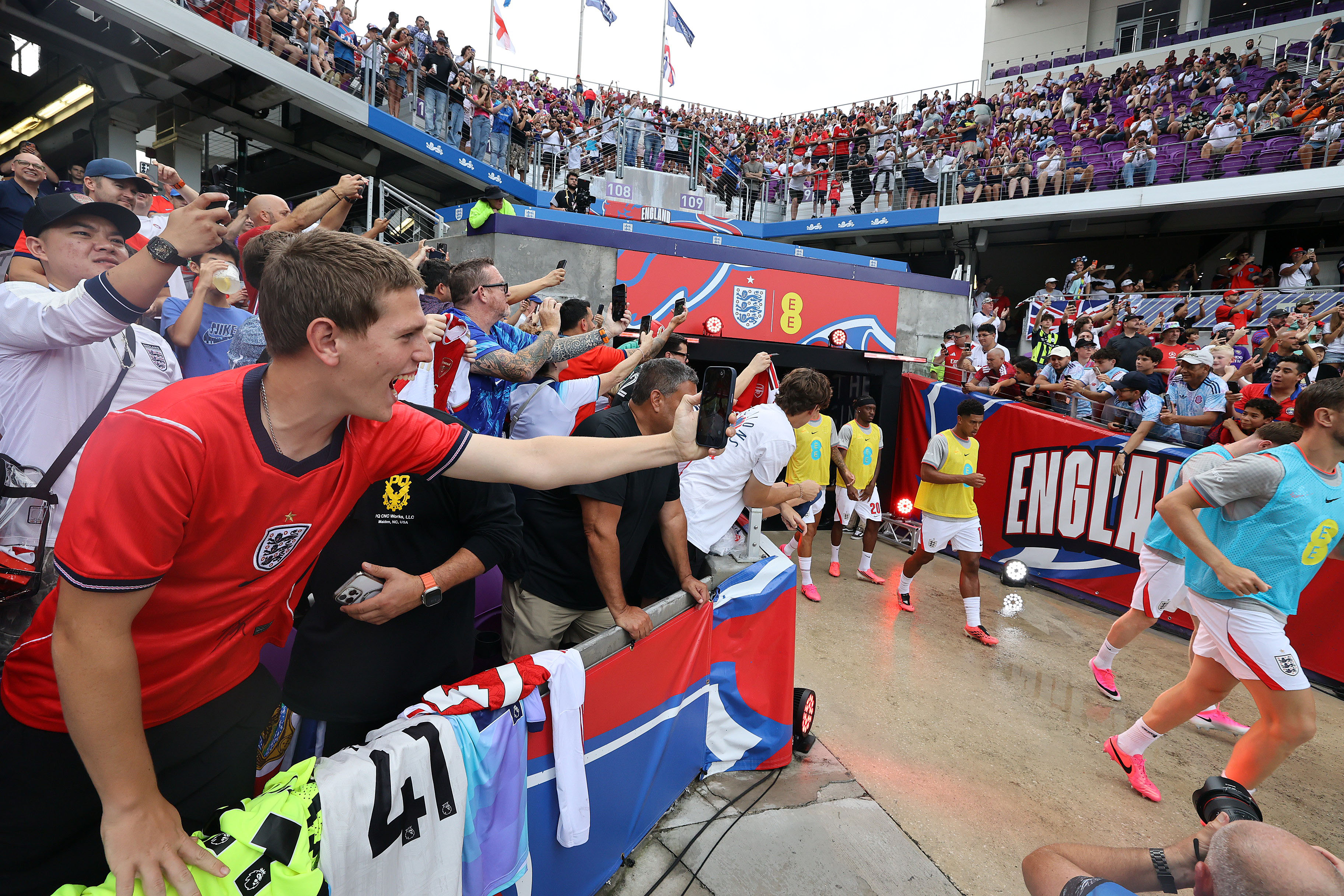Fans cheer as teams run onto the pitch for the...