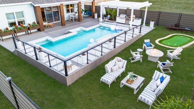 The backyard at HGTV Smart Home 2026 is designed for easy outdoor living. A resort-style pool with a swim-up bar anchors the space, while an outdoor kitchen and covered patio make entertaining simple. Lounge areas, a putting green and a movie-night setup add even more ways to enjoy the outdoors. (Courtesy of Scripps Networks)