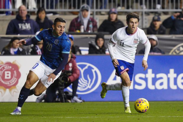 United States' Brenden Aaronson, right, dribbles away from Paraguay's Braian Ojeda (20) during the second half of an international friendly soccer match, Saturday, Nov. 15, 2025, in Chester, Pa. (AP Photo/Derik Hamilton)