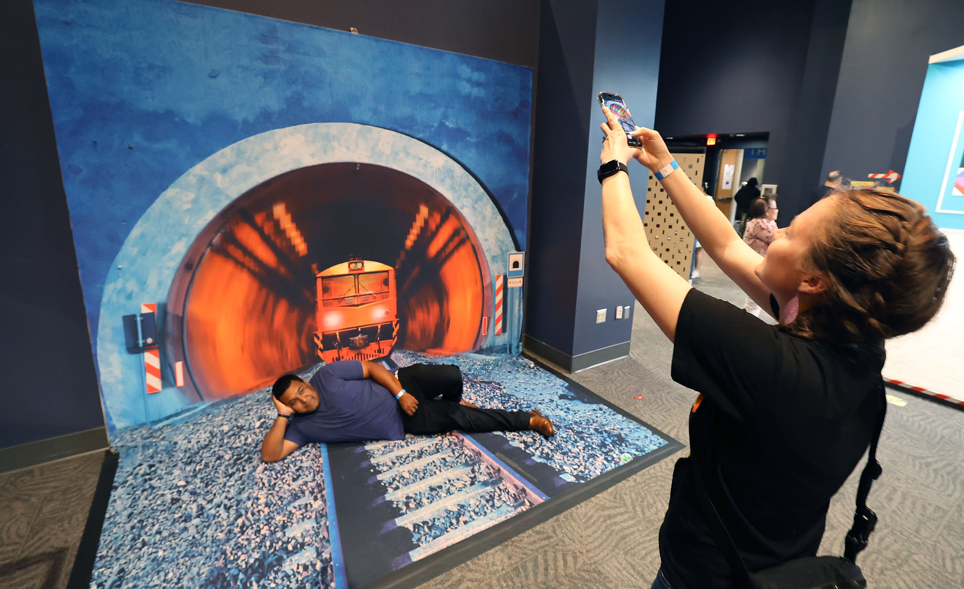 Guests take photos at an optical illustration exhibit during Orlando...