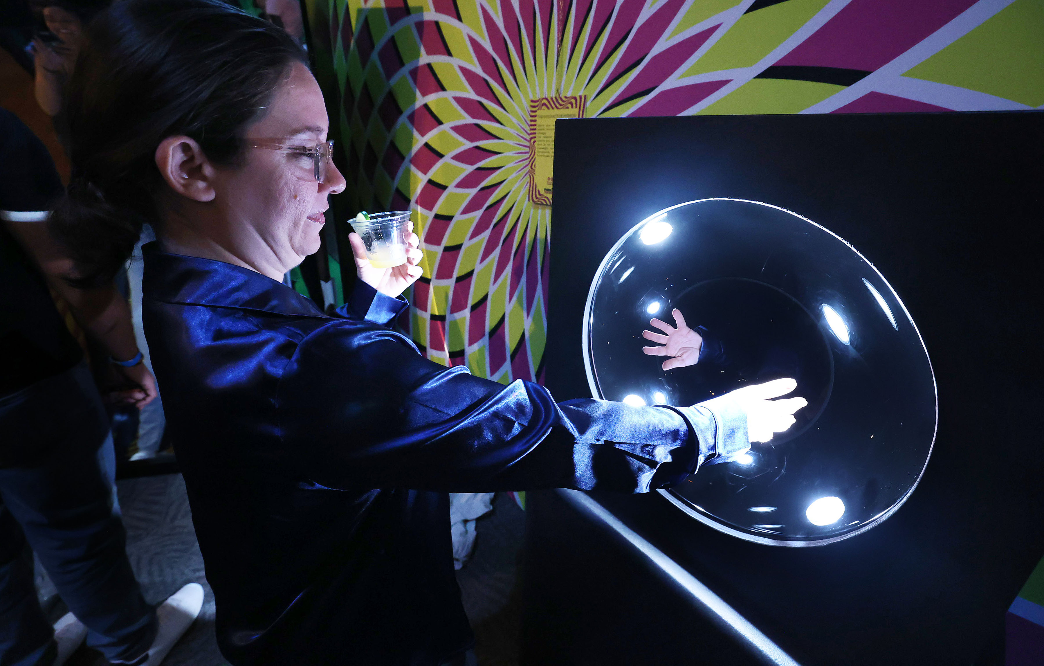 A guest enjoys an optical illusion display during Orlando Science...