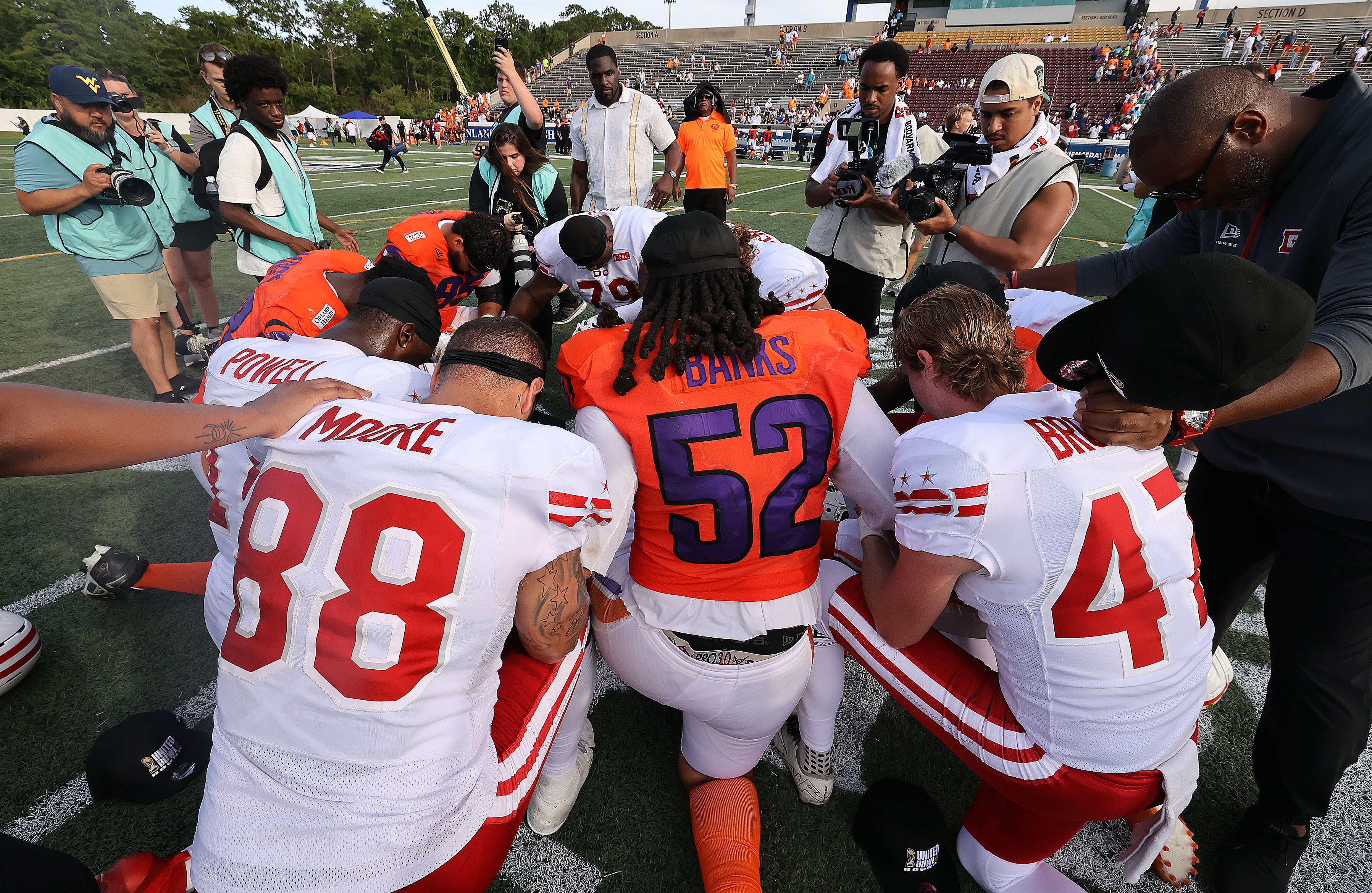 Players from both teams pray at midfield after the Orlando...