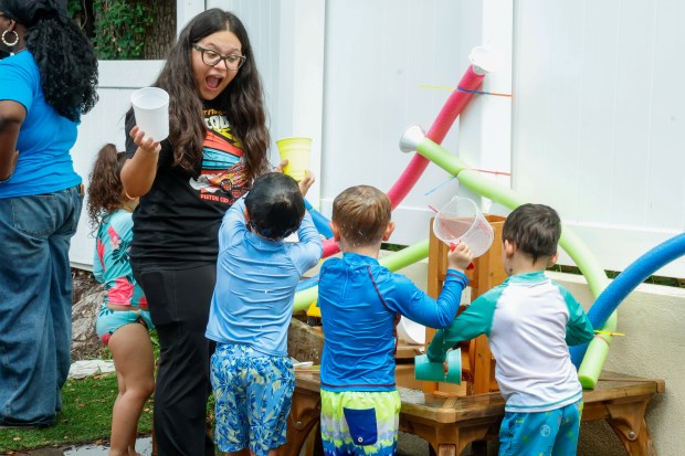 Pre-K teacher assistant Laura Lopez plays with preschoolers at the water table during activities at Hyer Street Preschool in Orlando on Wednesday, June 10, 2026. (Rich Pope/Orlando Sentinel)