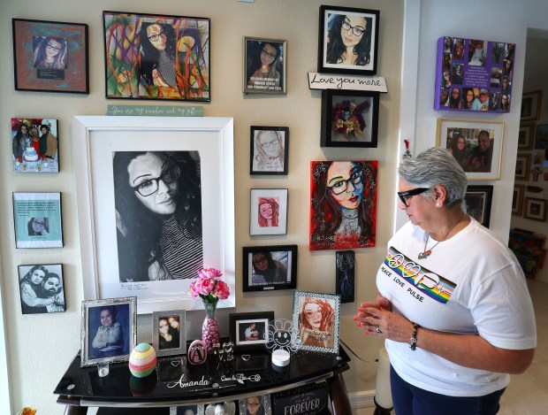 Mayra Alvear Benabe with the memorial photos of her daughter Amanda Alvear, at her home in Haines City on May 26, 2026. (Joe Burbank/Orlando Sentinel)