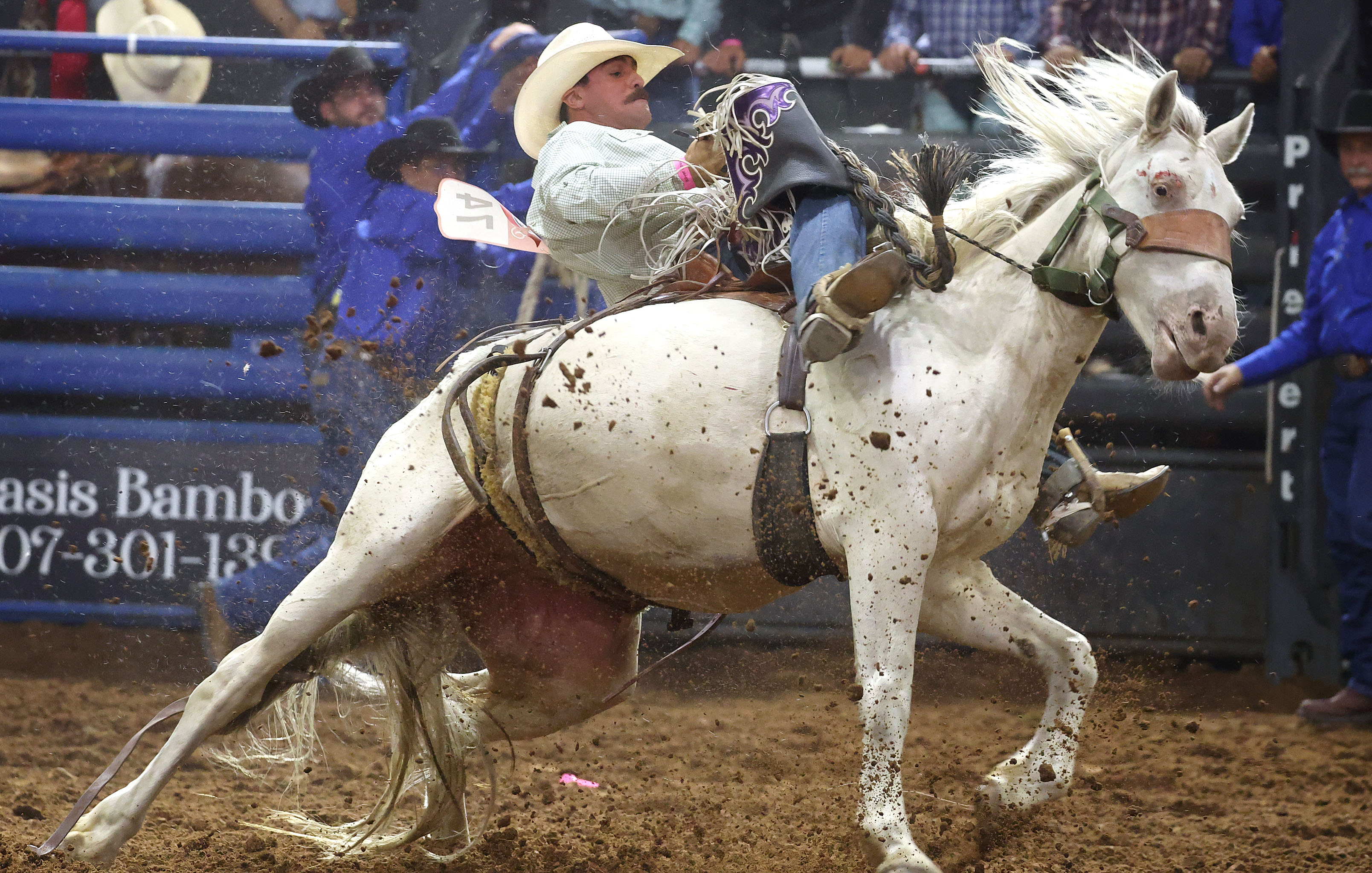 Wyatt Lavergne holds on to a bucking bronc during the...