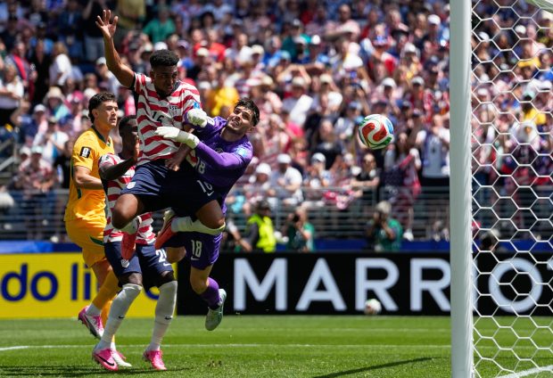 United States' Alex Freeman, center, scores his side's second goal past Australia goalkeeper Patrick Beach during the World Cup Group D soccer match between the United States and Australia in Seattle on June 19. (Lindsey Wasson/Associated Press)
