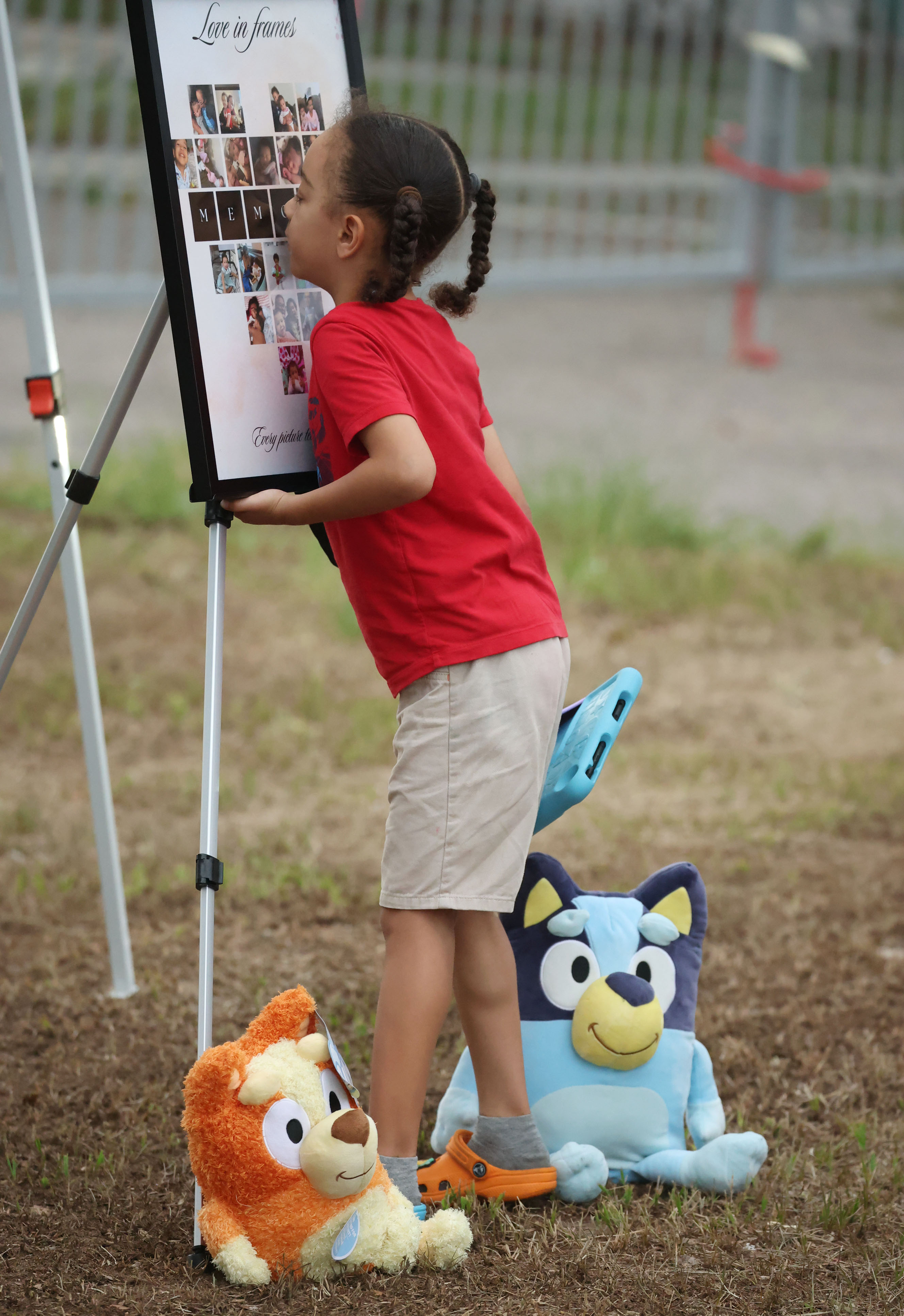 A child looks at photographs displayed during a community vigil...