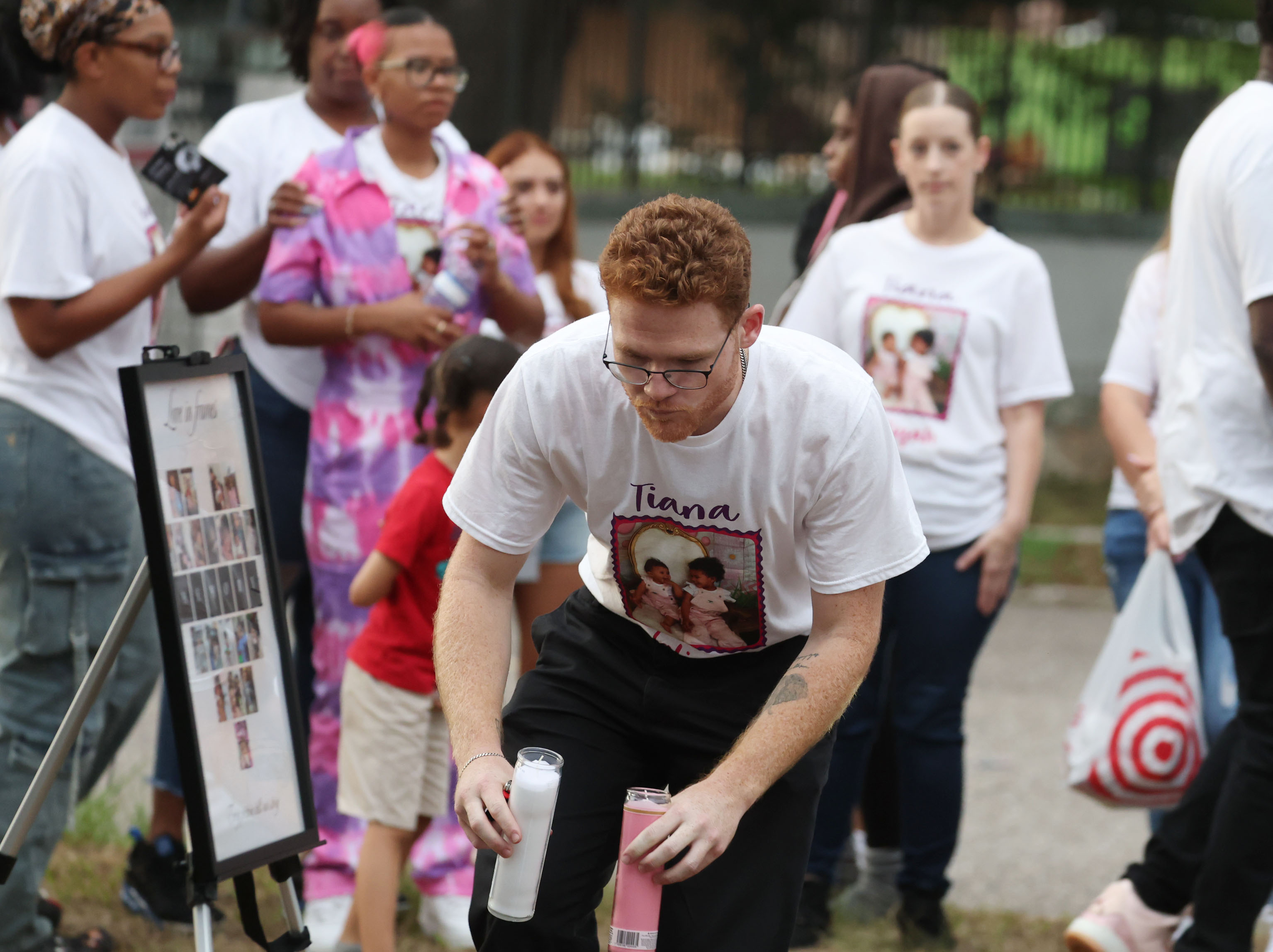 A mourner carries candles during a community vigil for 2-year-old...