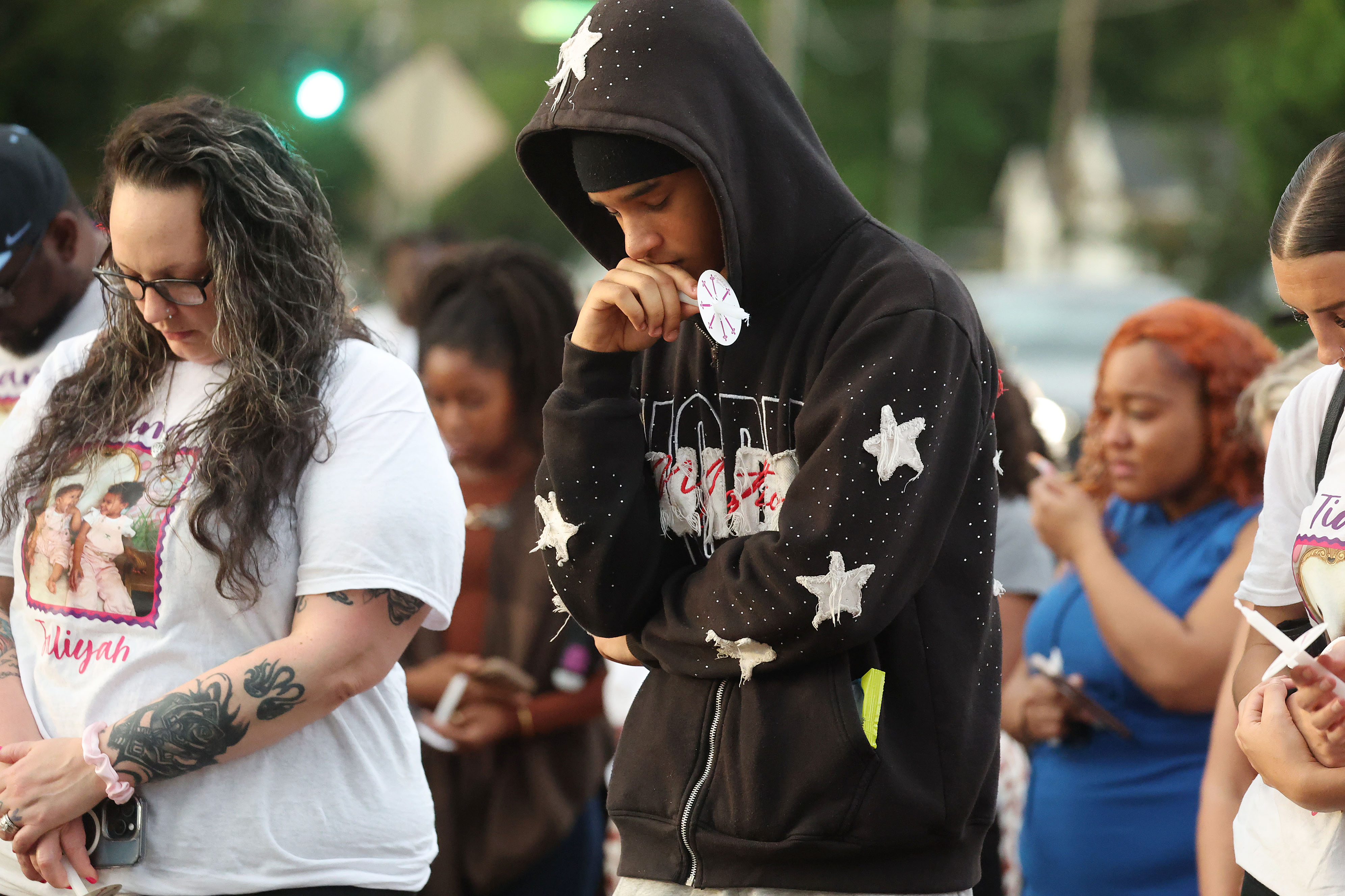 Mourners grieve during a community vigil for 2-year-old Tiana Rae...