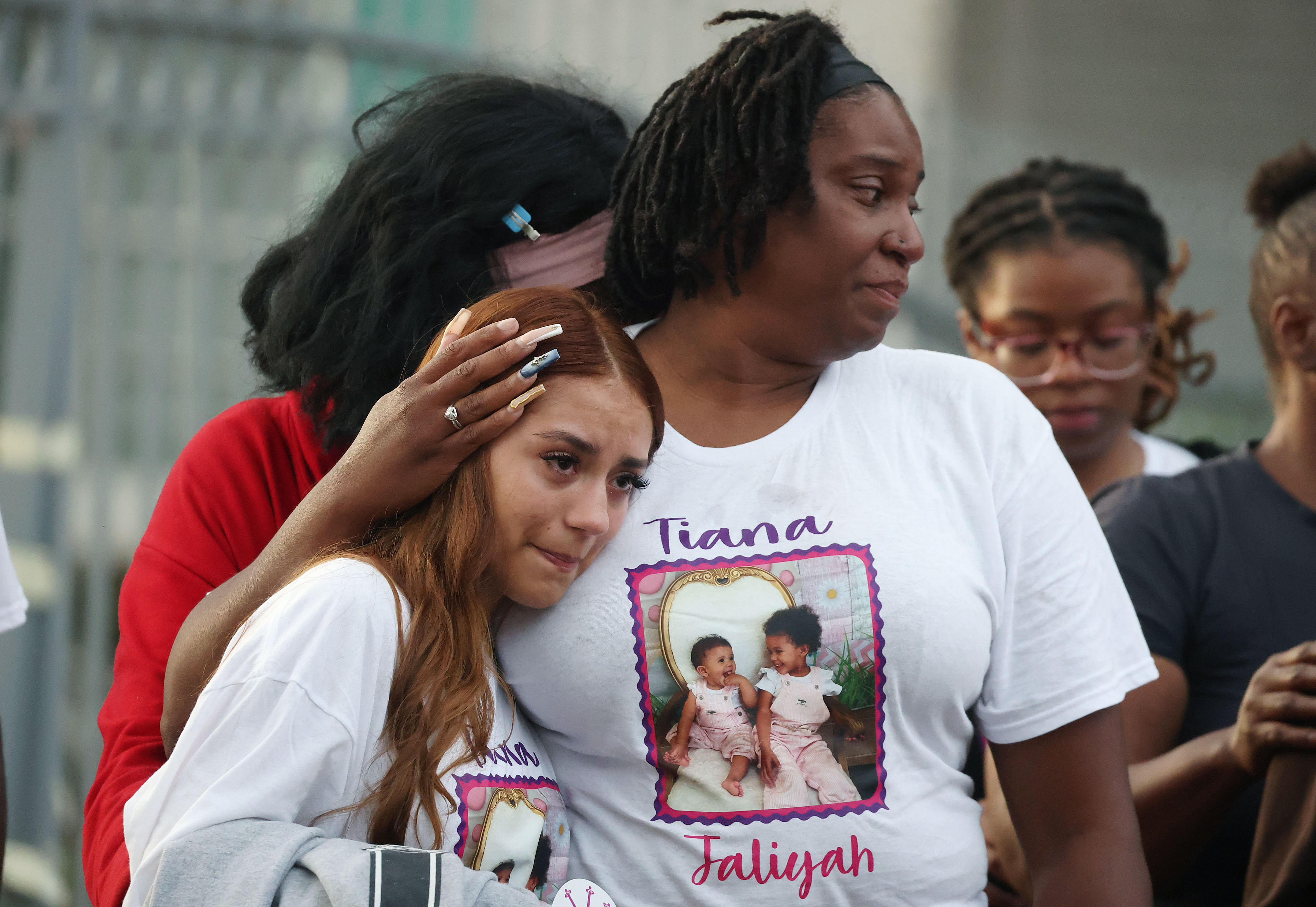 Mourners grieve during a community vigil for 2-year-old Tiana Rae...