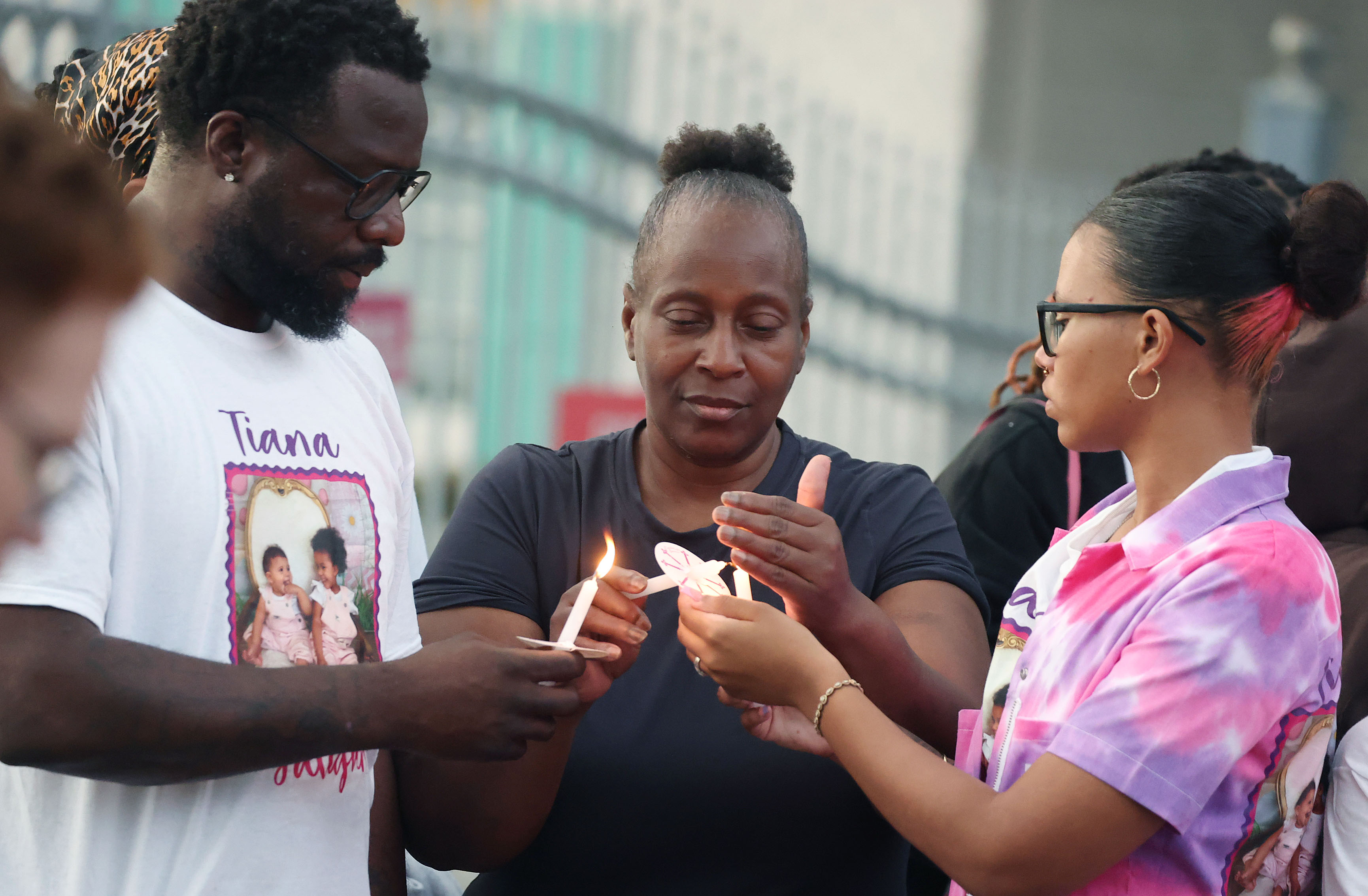 Mourners light candles during a community vigil for 2-year-old Tiana...