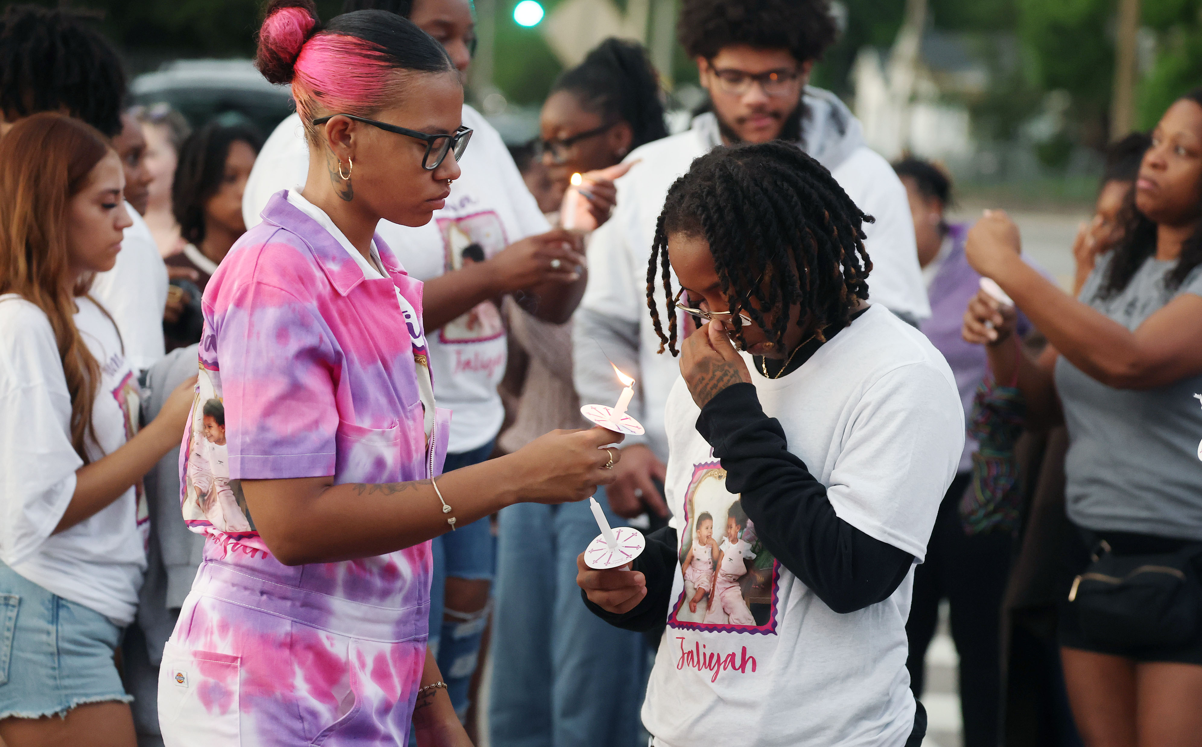 Mourners light candles during a community vigil for 2-year-old Tiana...