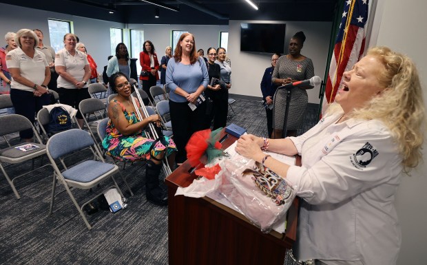 Air Force veteran Susan Aungst, right, joyfully sings "God Bless America" during an opening ceremony at the Women's History & Cultural Center in Orlando on Wednesday, June 17, 2026. (Stephen M. Dowell/Orlando Sentinel)